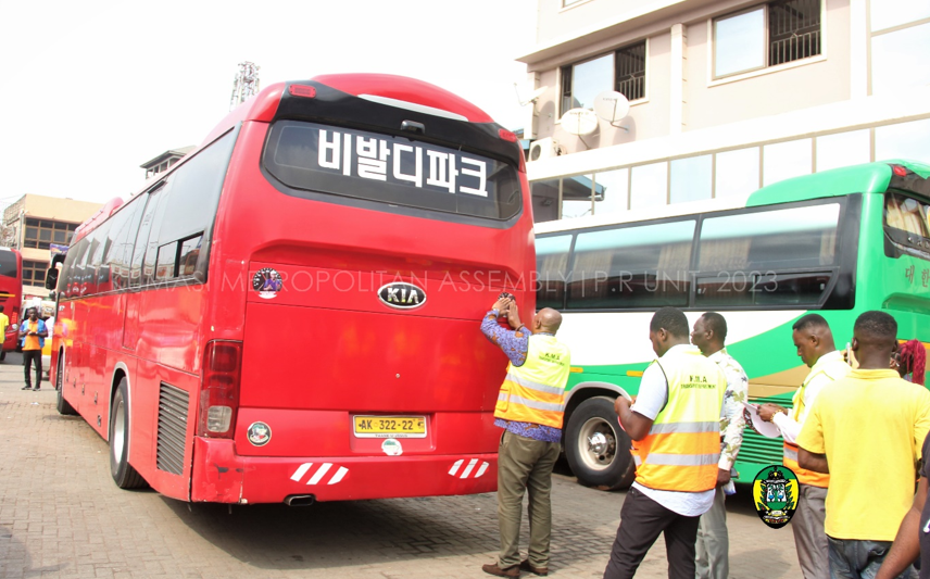 Hon. Sam Pyne pasting the campaign sticker on the VIP buses